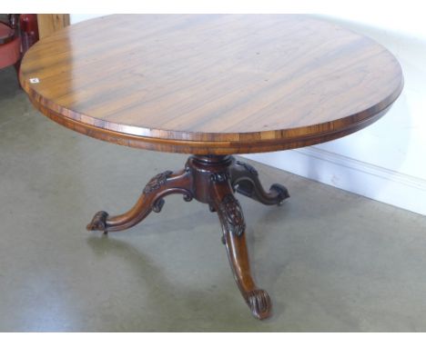 A 19th century rosewood tilt top breakfast table on an acanthus and scroll carved tripod base - Diameter 1.21 m