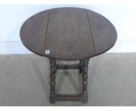 A 19th century oak drop leaf table in the form of a joint stool - Height 57 cm x Width 68 cm closing to 33 cm - Length 69 cm 