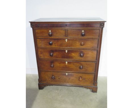 A good early 19th century oak Country chest with a blind drawer above two short and four long drawers flanked by quarter turn