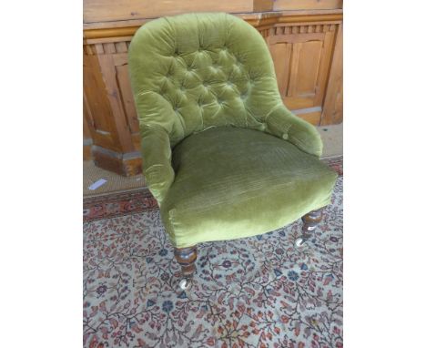 A Victorian walnut nursing chair with stuffed buttoned back,  standing on turned front and squared back legs with brass and c