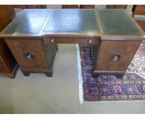 An early 1900's Continental oak and walnut kneehole desk with a leather inset top central drawer and two cupboard doors - Wid