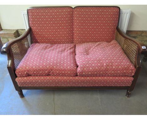 A beech two seater Bergere sofa in red upholstery