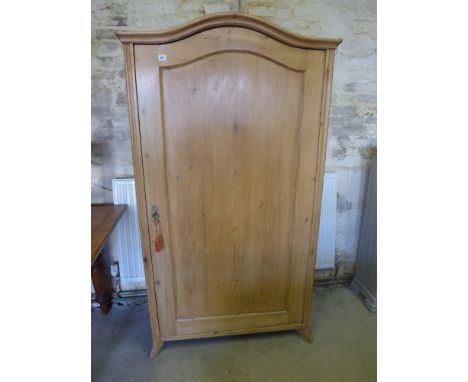 A 19th century Continental pine wardrobe with arched top and panelled door - fitted with a single shelf and hanging rail, sta