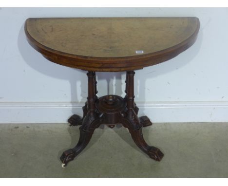 A 19th century walnut and inlaid demi lune card table the top opening to full circle with felt lined top raised on quatrefoil