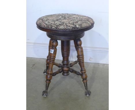 A late Victorian stained beech piano stool with revolving top - Height 48 cm up to 58 cm - standing on steel claw feet with g