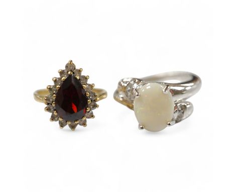 A modern 9ct white gold and single stone cabochon white opal set ring, size N and a 9ct gold, garnet and white sapphire? clus