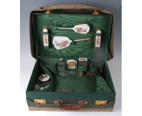 An Art Deco green leather, silver and enamel fitted travelling vanity case, having canvas outer cover, stitched detail with b