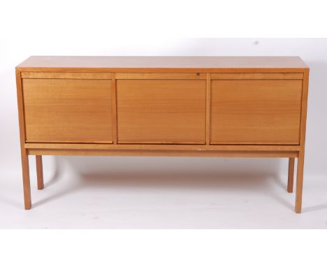 A 1970s teak sideboard, having three roller tambour doors and raised on rectangular supports, h.90cm, w.171cm, d.42cm