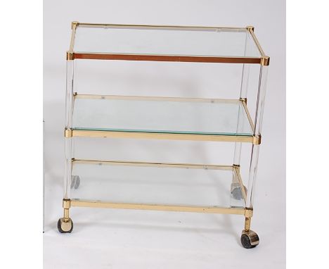 A 1980s probably Italian gilt brass, lucite and bevelled glass inset three-tier tea trolley, raised on roller castors, h.69.5