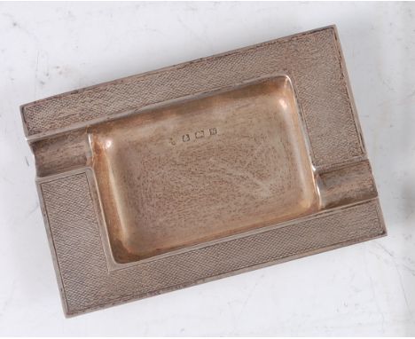 A 1960s silver ashtray, having engine turned raised border, with two opposing cigarette rests, makers mark rubbed, Birmingham