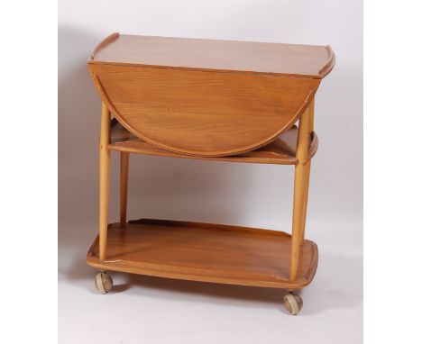 A 1960s Ercol blond elm dropflap three-tier tea trolley, having raised borders, on roller castors, h.75cm, w.95cm (leaves up)