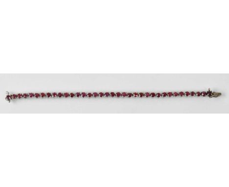A white metal ruby set tennis bracelet, rubies totalling approx 3.5ct, length 16.5cm, approx 11.5g.
