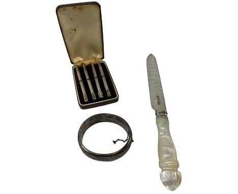 A cased set of four sterling silver propelling pencils, a hallmarked silver bangle, Birmingham 1951, and a mother of pearl ha