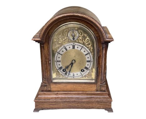 An early 20th century oak cased mantel clock with brass face and silvered dial set with Roman numerals, height 30.5cm, width 