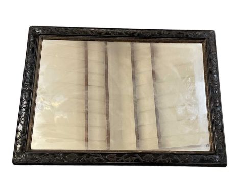 An early 20th century Chinese carved hardwood mirror, the frame decorated with carved foliage, 57 x 43cm.