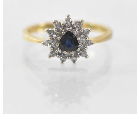 An 18ct yellow gold sapphire and diamond set cluster ring, the central heart shaped sapphire surrounded by multiple small dia