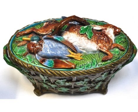 A Majolica game pie tureen and cover with inner ceramic liner, the tureen of oval form with basket weave sides set with oak b