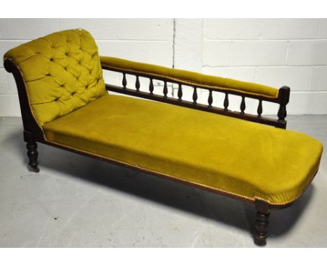 An early 20th century mahogany chartreuse upholstered button back chaise longue, with carved ring turned supports terminating