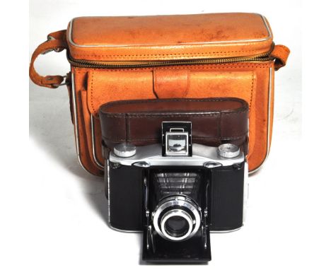 An Ensign Selfix 12-20 folding roll film camera with original carrying case and period holdall with accessories.
