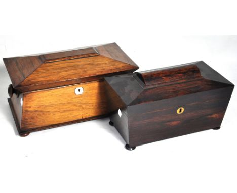 An early Victorian rosewood tea caddy of sarcophagus form, the hinged lid revealing twin compartments flanked by turned handl