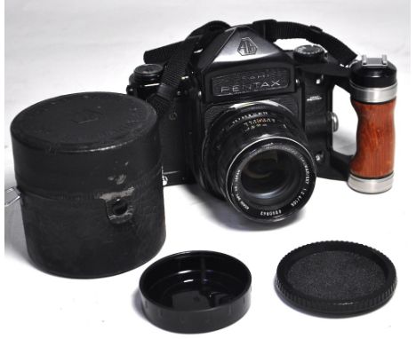 A Pentax 67 camera with 105mm lens, wooden hand grip and carrying strap. CONDITION REPORT Camera serial number 4118463, lens 