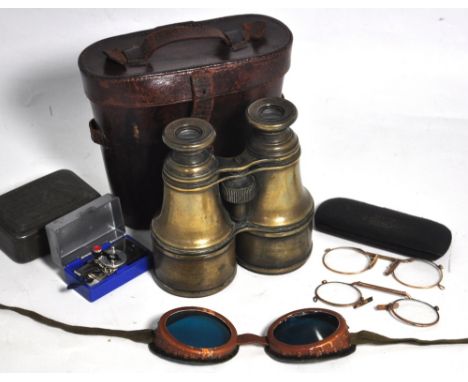 A pair of early 20th century brass cased binoculars in original leather case, a pair of early 20th century coloured goggles i