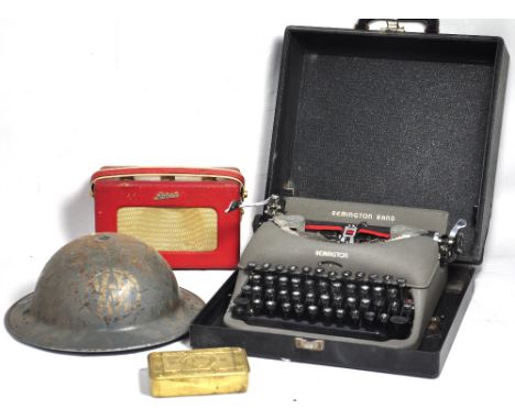 A WWI tobacco tin and British soldiers helmet, together with a small radio, camera and vintage typewriter (5).