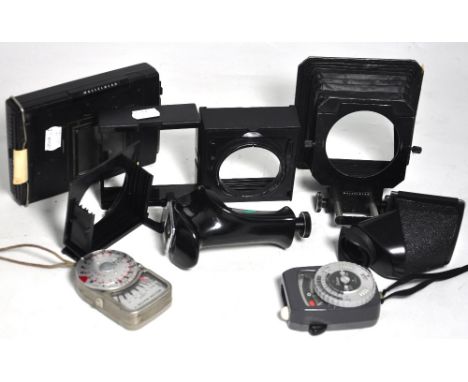 A group of Hasselblad accessories to include a pistol grip, bellows lens shade, polaroid film back, body, lens caps and two e