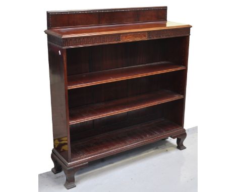 An Edwardian mahogany open bookcase, the raised back above fretwork decorated frieze, three shelves and raised on ogee bracke