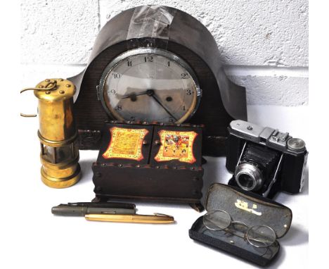 A 1940s oak cased mantel clock with silvered dial, a reproduction brass miners lamp, a leather cased German camera, a cased p