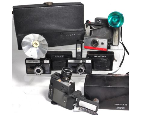 Two Cosmic Symbol 35mm cameras both with case and flash gun, a Polaroid land camera model 104 complete with flash unit and ou
