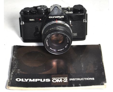 An Olympus OM-2n camera in rare black finish with f1:8 50mm standard lens, filter and lens cap. CONDITION REPORT Camera seria