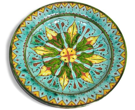 A Della Robbia circular shallow bowl decorated with stylised leaves in shades of yellow, pale turquoise and green, incised ma