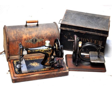 A vintage sewing machine in a wooden case and another Victorian sewing machine in a metal case (2).