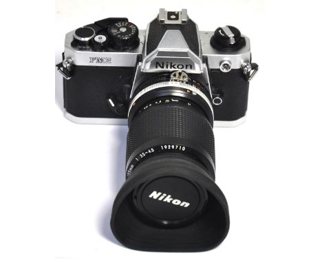 A Nikon FM2 35mm SLR camera fitted with a zoom Nikkor 35-105mm zoom lens, filter, lens cap and hood. CONDITION REPORT Serial 