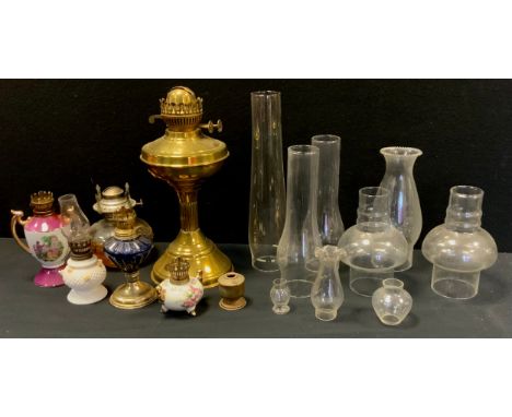 A quantity of oil lamps including brass, milk glass, ceramic, conforming shades; etc 