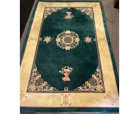 A large Chinese deep-pile woollen rug / carpet, in deep green, and subtle tones of pink, jade, and cream, 277cm x 184cm. 