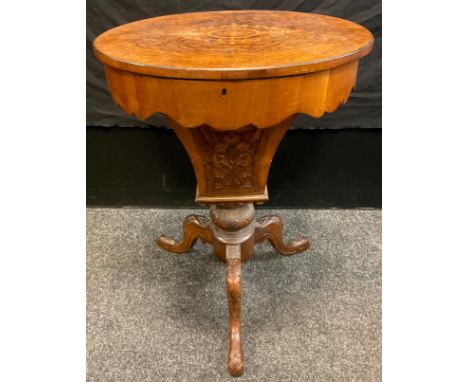 A Victorian walnut oval work table, the quarter veneered top inlaid with stylised foliage, the interior fitted with lidded co