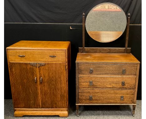 A mid 20th century oak dressing table, bevelled circular mirror, three long graduated drawers, tapered square legs, ceramic c