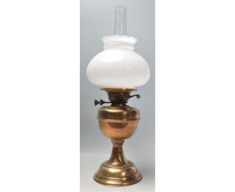 A 1950s 20th century brass oil lamp. The lamp having a milk glass shaped with clear glass funnel, glass oil reservoir raised 