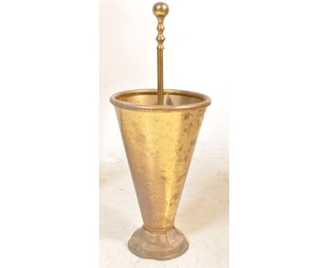 An early 20th century 1930s brass stick stand of tapering form raised on a circular base. The stick stand has a circular topp