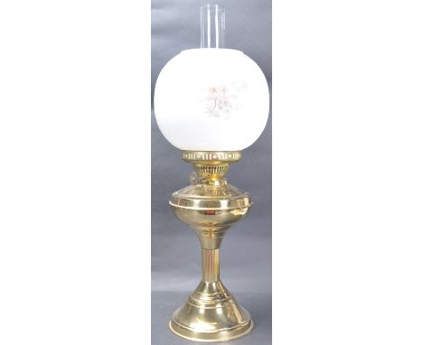 An early 20th Century oil lamp having an opalescent shade with floral detailing, brass reservoir, raised on column atop a cir
