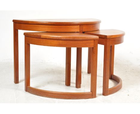 A vintage retro 20th century circa 1970’s demi lune teak wood nest of tables having shaped top above raised on curved legs.