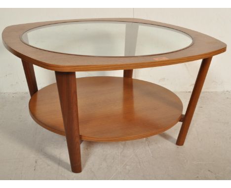 A retro vintage mid 20th century teak coffee table by Remploy of circular form having a glass drop in table top raised on tap