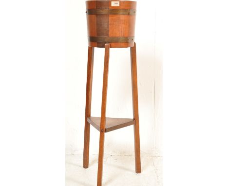 An Edwardian 20th century coopered jardiniere / planter raised on supports united by a shelf. Stamped R A Lister of Dursley, 