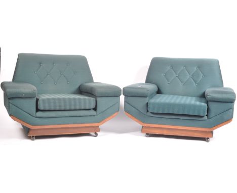 A pair of mid retro vintage 20th Century believed Danish armchairs / easy lounge chairs being upholstered in a dark turquoise