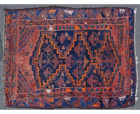 An early 20th century Persian Islamic hand woven carpet rug having large diamond shape medallions with oil lamp / floral bask