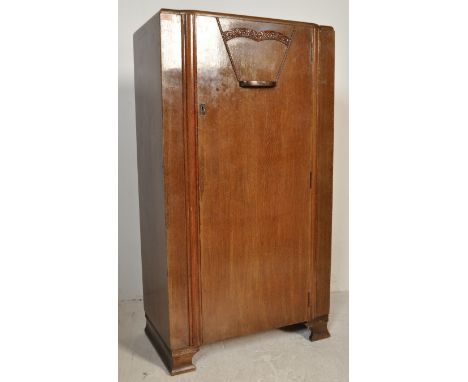 A 20th century 1940s Art Deco oak veneer tallboy / wardrobe having full size single door with floral motifs to the top open t