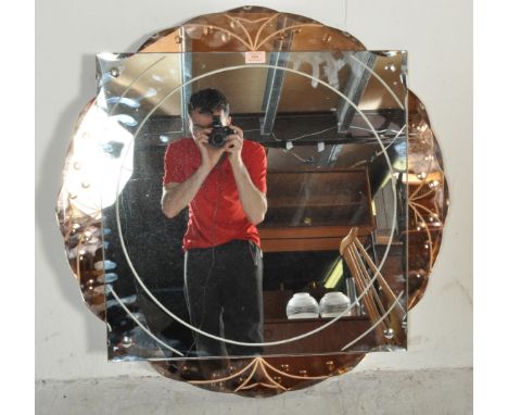A vintage 1950s mid 20th century Art Deco style peach glass mirror of circular form having etched decoration to the rim. Meas