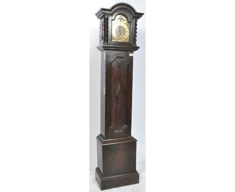 An early 20th century oak longcase / grandfather clock having a brass clock face flanked by barley twist supports with spandr